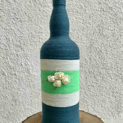 Hand-crafted-yarn-bottle-vase-dull-blue-white-flowers